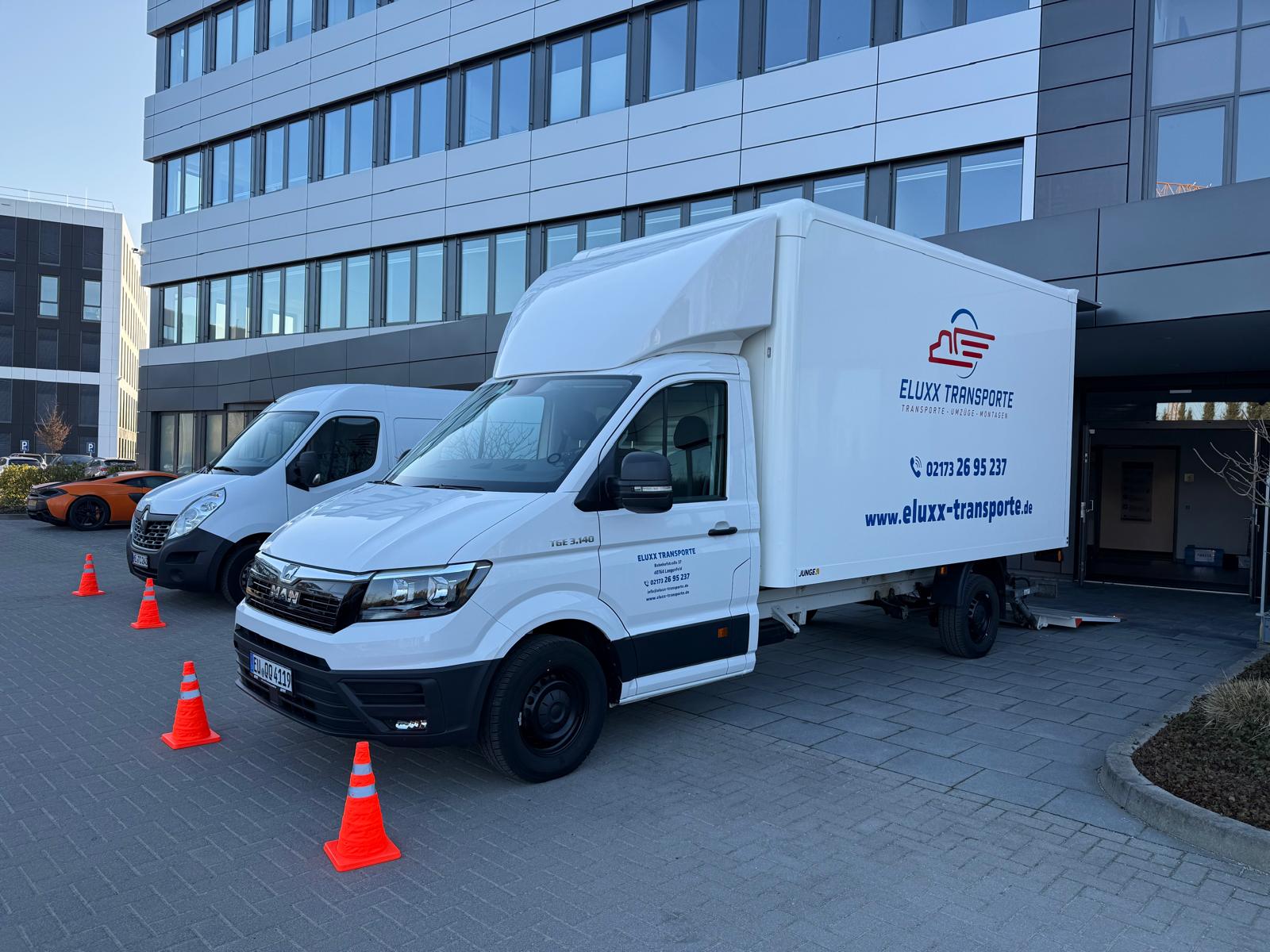 Professioneller Umzugsaufbau vor Bürogebäude mit Sicherheitskegeln